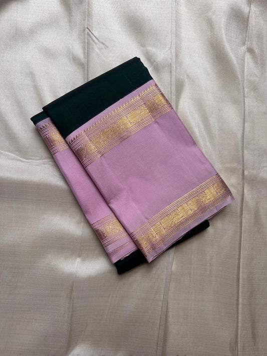Deep green Kanchipuram silk saree with lavender zari border folded flat lay