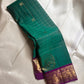 Sorgavaasal Kili – Pure Silk Kanchipuram Saree in Teal with Purple Zari Kattam
Intricately handwoven with traditional zari kattam checks and adorned with exquisite zari-woven Yazhi buttas, this saree features a vibrant teal body paired with a regal purple