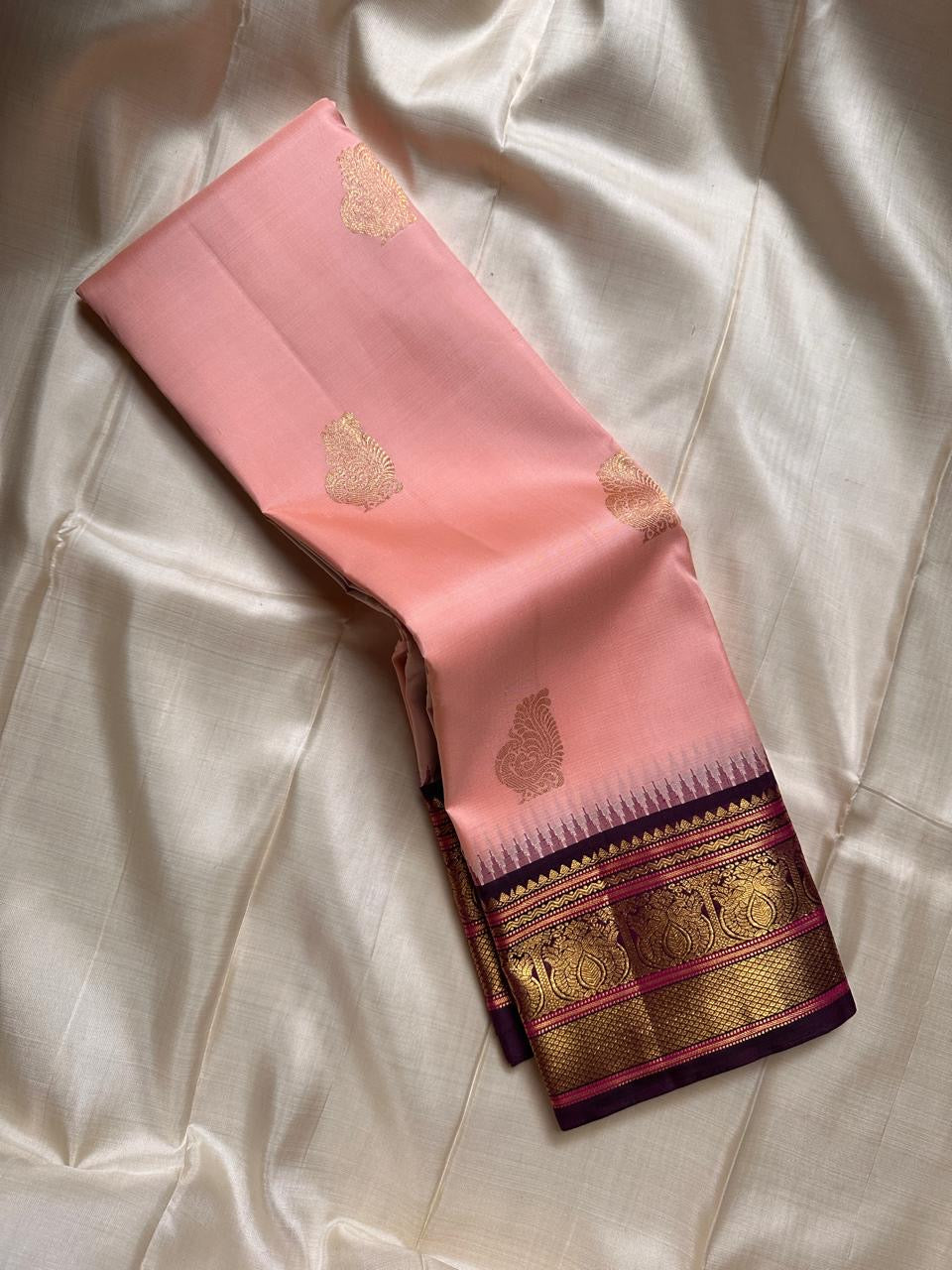 Mohana peach 🌸✨ – Graceful Peach Pure Kanchipuram Silk Saree with Handwoven Zari Peacocks 🦚, Deep Purple Peacock Border 💜🦚, Pillayar Moggu Detailing 🌺, & Intricately Woven Grid Zari Pallu 🎀💛