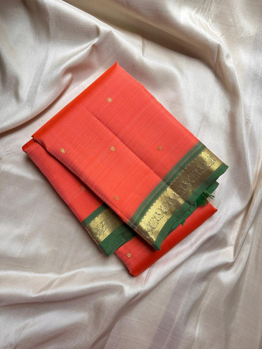Pure silk kanchipuram orange peach  color body with zari buttas , green mayil slim border