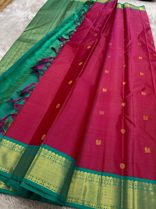 A Very unusual raspberry pink and teal vairaoosi pure silk Kanchipuram Mayil and coin zari buttas all over the boat on top of the zari stripes ! Detailed mayil paisley chakram grid pattern on Pallu 💕