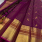Angle view of magenta Kanchipuram saree showing gold zari border, peacock buttas and contrast pallu