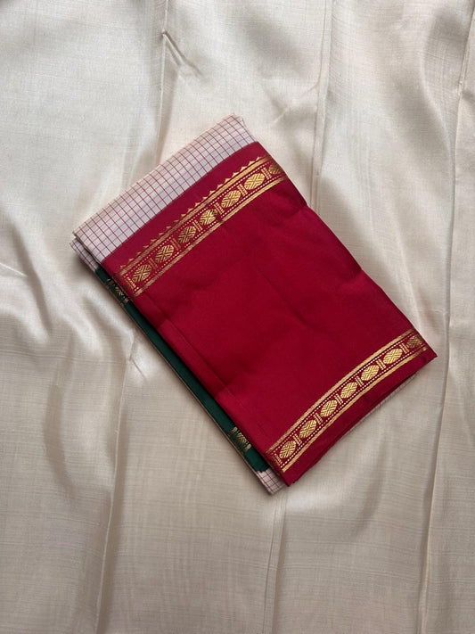 Ivory saree with fine red kattam checks and maroon zari border folded flat lay