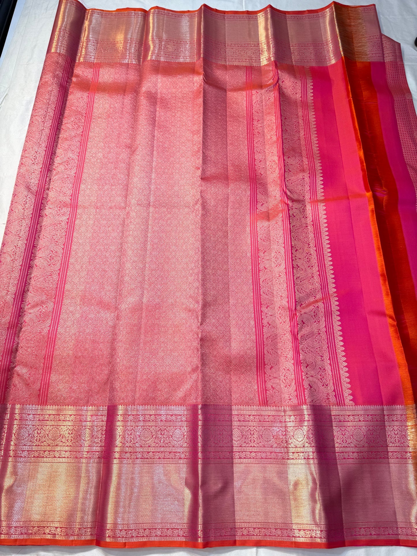 Peach Pink Flower Butta – Coral-pink shot body with micro checks & floral buttas

Handwoven Kanchipuram silk with delicate copper-pink zari work

Elegant floral vines on borders • grand rose-gold brocade pallu

Silk Mark Certified | Fall & Pico Done |