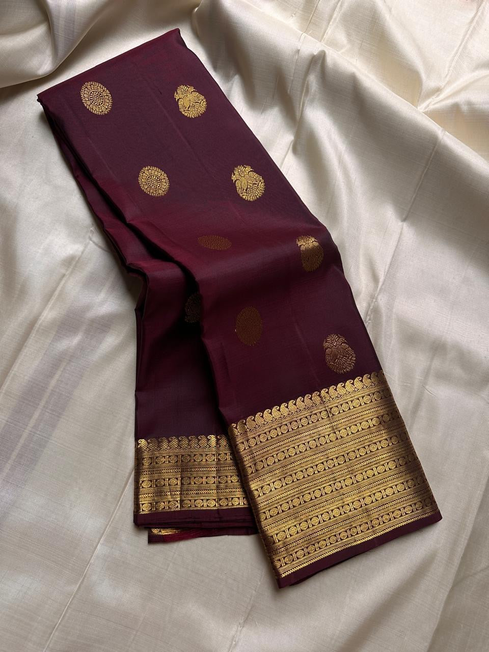 Cholai — Pure Silk Kanchipuram Saree
Deep Arakku Maroon with Gold Coin & Mankolam Buttas
Rudraksha & Vanki Zari Borders | Brocade Gold Pallu
Heritage Handloom Weave | Blouse Attached
Silk Mark Certified ✅ • Fall & Pico Done ✅ • Blouse Stitching ($30) ✅ •