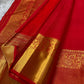 A traditional Kanjivaram (Kanchipuram) silk saree, vibrant red orange peacock floral motifs bavanji border and ornate grid motif Pallu