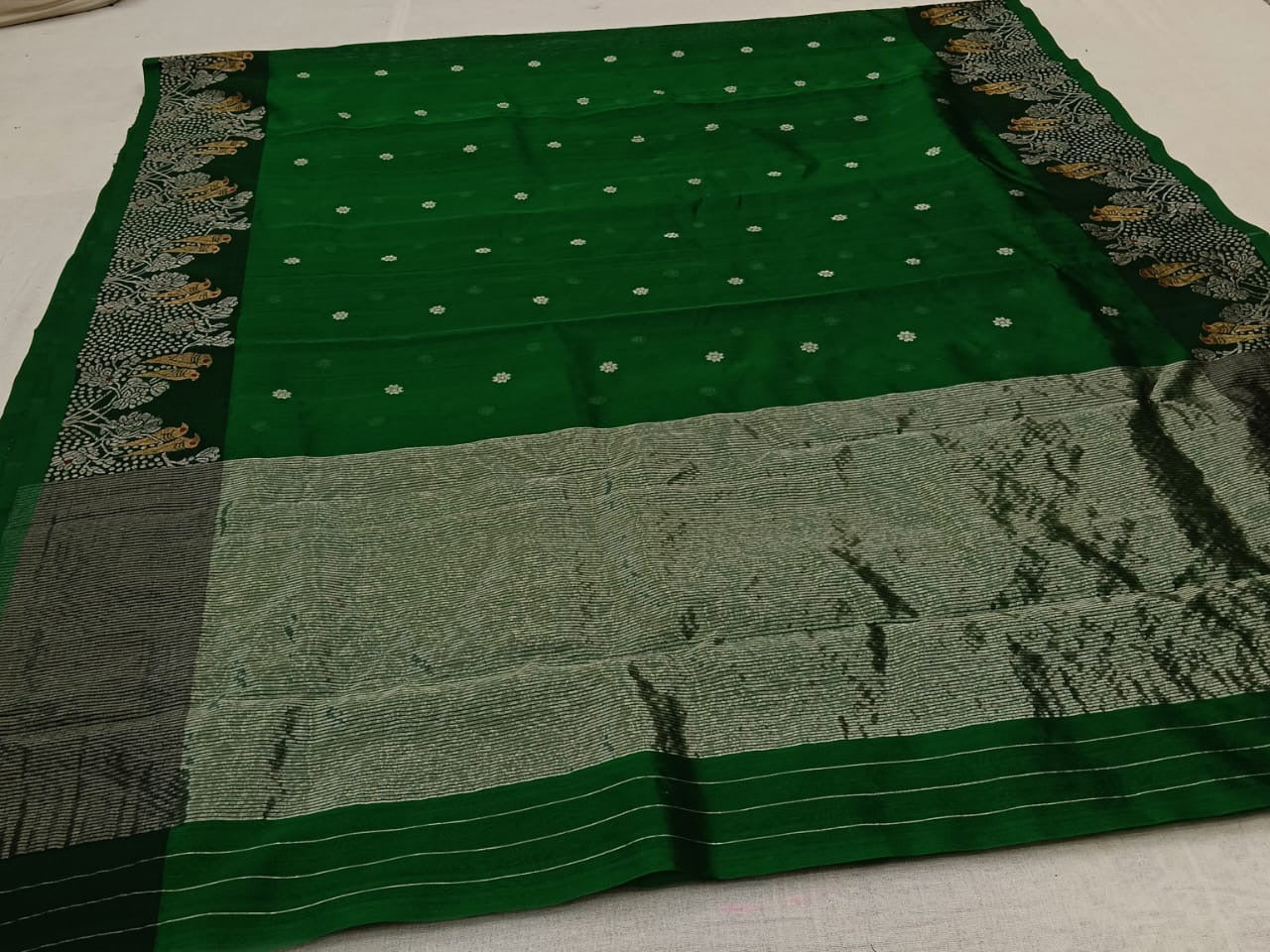 green chanderi silk saree folded lengthwise highlighting zari woven border