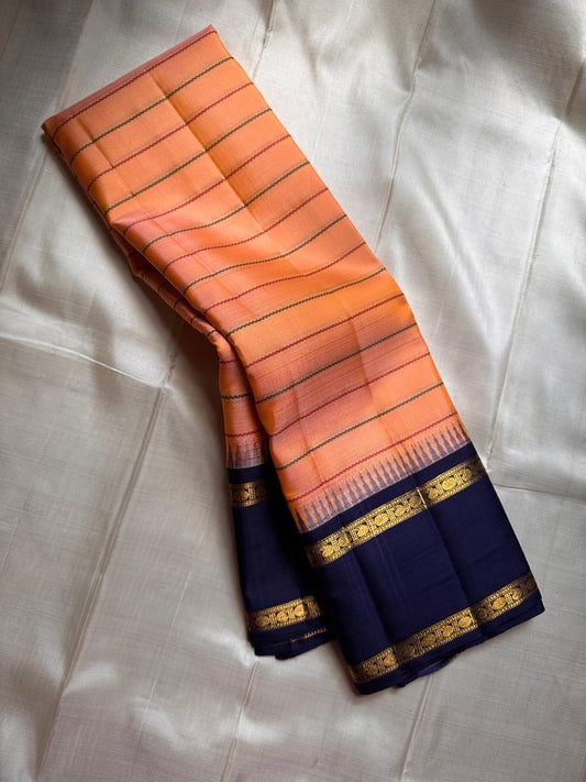 Peach Veldhari ✨ – Pure Kanchipuram Silk Saree with Royal Blue Border & Pallu

Peach-Orange Veldhari Striped Body with Subtle Green & Maroon Accents

Royal Blue Korvai Border with Intricate Gold Zari Motifs

Majestic Royal Blue Zari Brocade Pallu