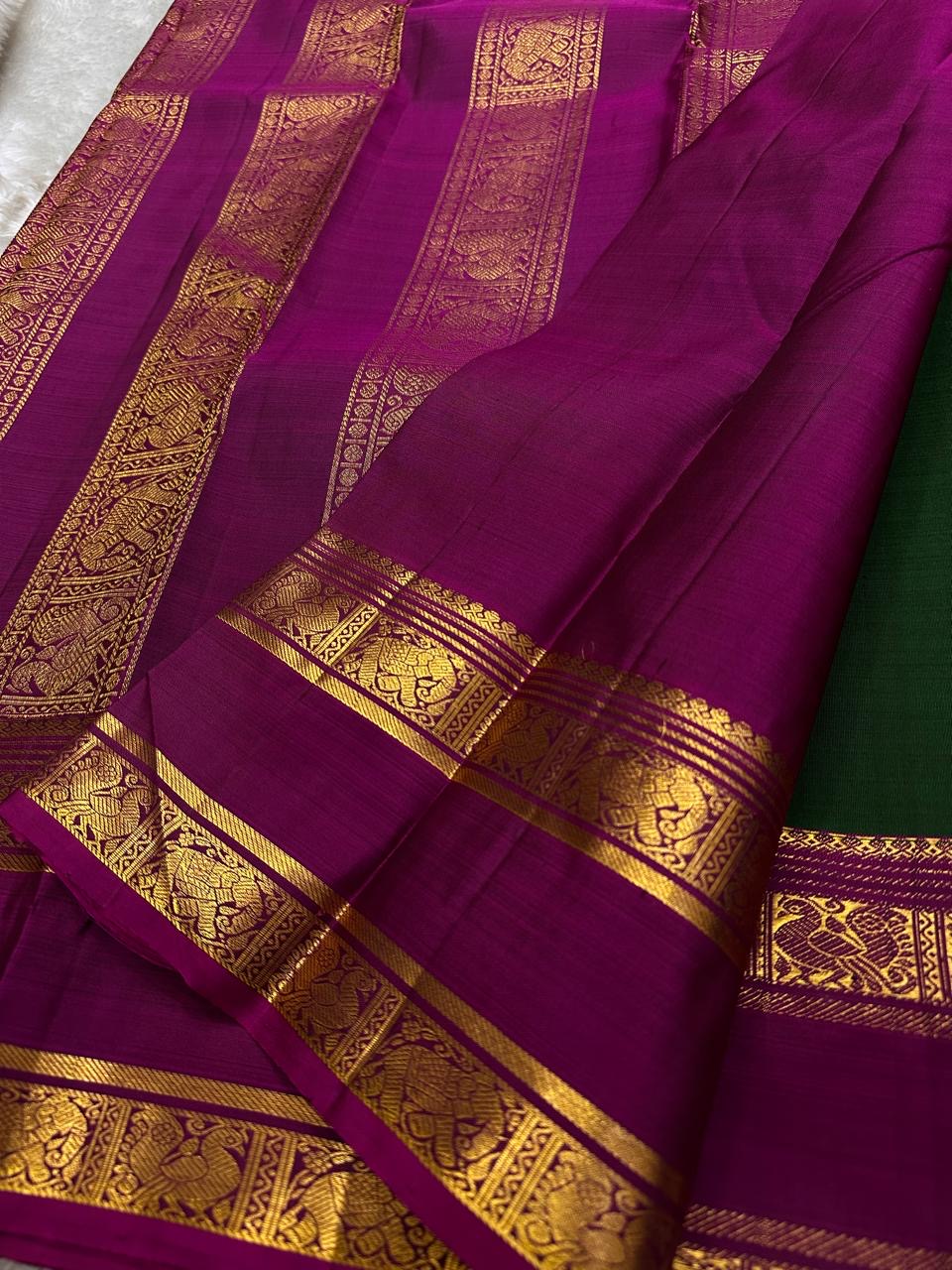Magenta pallu close-up with intricate gold zari border featuring woven animal and floral motifs
