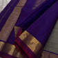 Varnam – Dove Tail Gray & Purple, a Kanchipuram silk saree where elegance meets bold expression. The soft dove tail gray base is adorned with vibrant magenta checks,Framed by a rich purple zari border and finished with an intricate contrast pallu