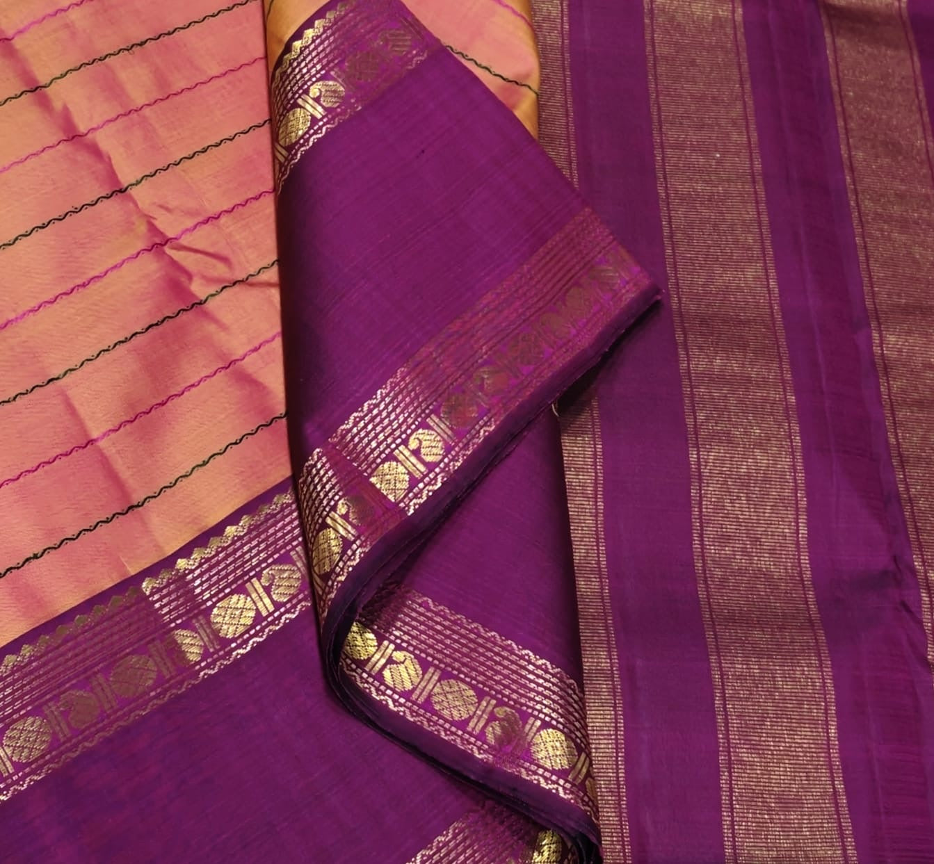Shanmugapriya – Pure Kanchipuram Silk Saree
Plum Body with Veldhari Silk Thread Lines ✨
Contrast Korvai Borders with Gold Zari Motifs
Grand Zari Brocade Pallu with Traditional Detailing
Silk Mark Certified | Blouse Piece Included | ships in two weeks