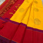 Mustard yellow and vermilion silk saree folded showing magenta contrast border