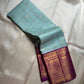 Shanti Blue – Pure Kanchipuram Silk Saree
Pleasant Blue Body with Purple Grid Checks & Zari Buttas
Deep Purple Korvai Border with Elephant & Floral Motifs
Majestic Zari-Dense Pallu in Traditional Weaving
Coordinated Blouse in Blue with Elegant Zari Border