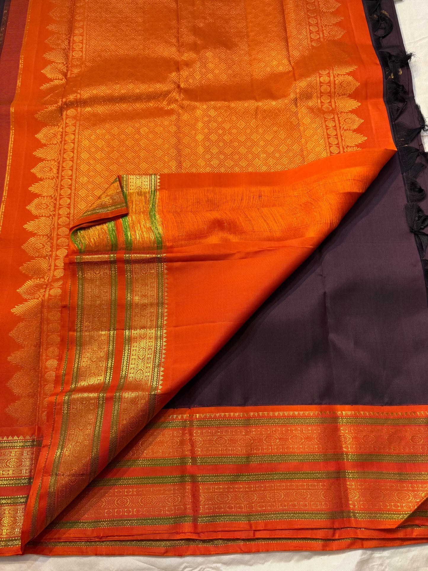 Deep Cocoa Manjari — Pure Kanchipuram Silk Saree
Rich cocoa-aubergine body with antique-gold manjari buttas, paired with a radiant kavi-orange korvai border and green selvedge accent.
Silk Mark Certified • Blouse Stitching Available ($30) • Free Shipping