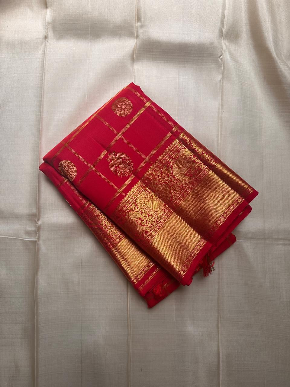 Srija – Red-Orange zari kattam  Kanchipuram Pure Silk Saree with Zari Checks, Kamalam Buttas & Vanasringaram Border