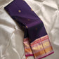 Shyamala—named after the deep, dark shade it embodies 💜 A pure Kanchipuram silk masterpiece with a rich purple body sprinkled with golden zari buttas. The contrast pink border glows with floral and paisley zari motifs, accented in coral and rose-gold, wh
