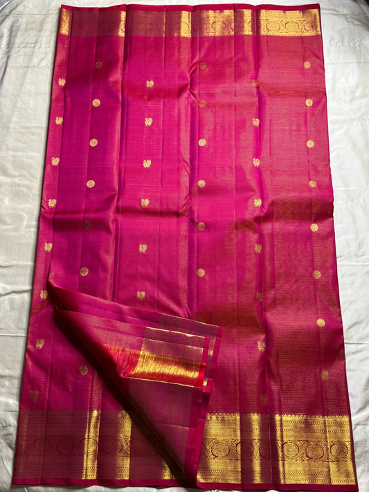 Nakshatra – Radiant pink Vairaoosi Kanchipuram Silk Saree Adorned with Mayil & Chakram Zari Buttas, Featuring an Ornate Kamalam and Floral Vine Zari Border, Flanked by Varisaipet Motifs, and a Pallu Woven with Sacred Thulasi Madams and Regal Kamalams