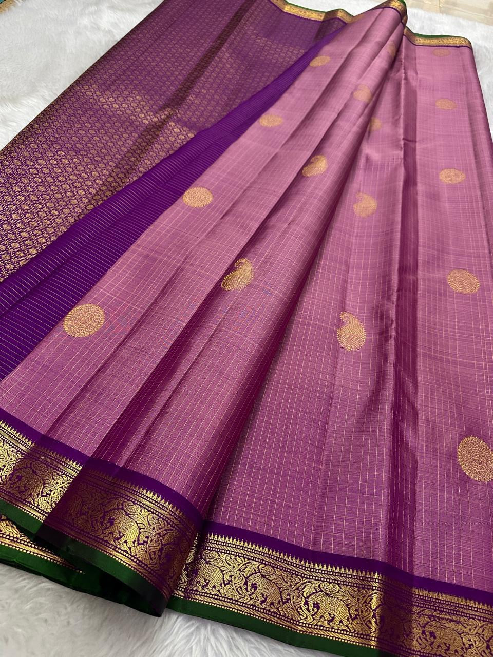 Petal Oosikattam ✨ – Pure Kanchipuram Silk Saree
Radiant Petal Pink Body in Oosi Zari Kattam Weave with Buttas
Deep Purple Korvai Border with Green Selvedge & Elephant Motifs
Majestic Purple Pallu with Intricate Gold Zari Brocade
Silk Mark Certified |