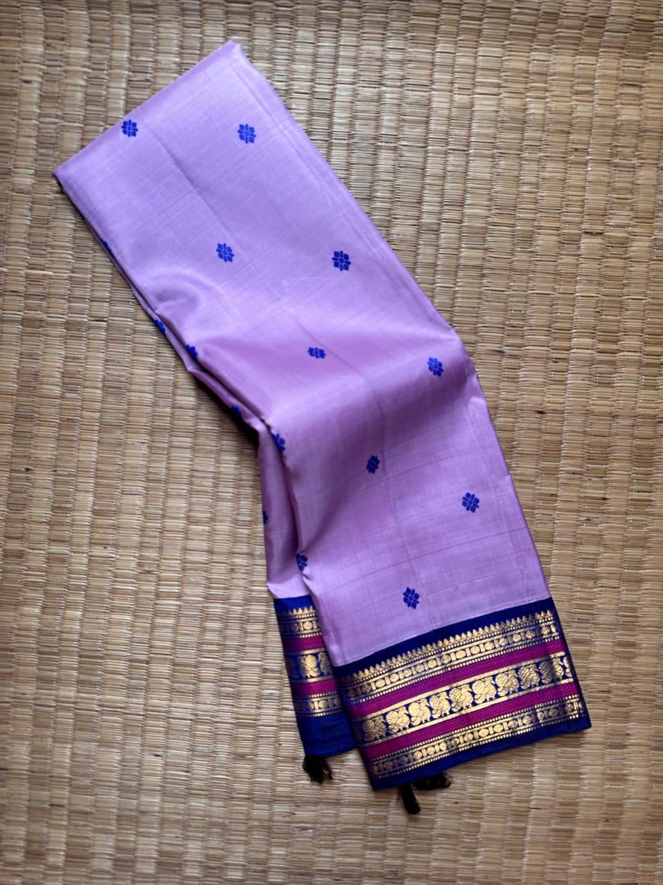 Lilac Indigo Pattu Butta — Pure Kanchipuram Silk Saree
Soft lilac body with indigo flower buttas, rich indigo–magenta gold zari borders and a grand indigo pallu.
Silk Mark Certified • Free Shipping within USA • Ships in Two Weeks