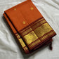 TEJAS – Vibrant Rust Orange Podi Kattam Kanchipuram Silk Saree

Micro-checks body with scattered gold chakram buttas; rich contrast maroon korvai borders

Grand circular annapakshi medallions in lustrous zari; ornate-jaal pallu & tassels

Silk Mark