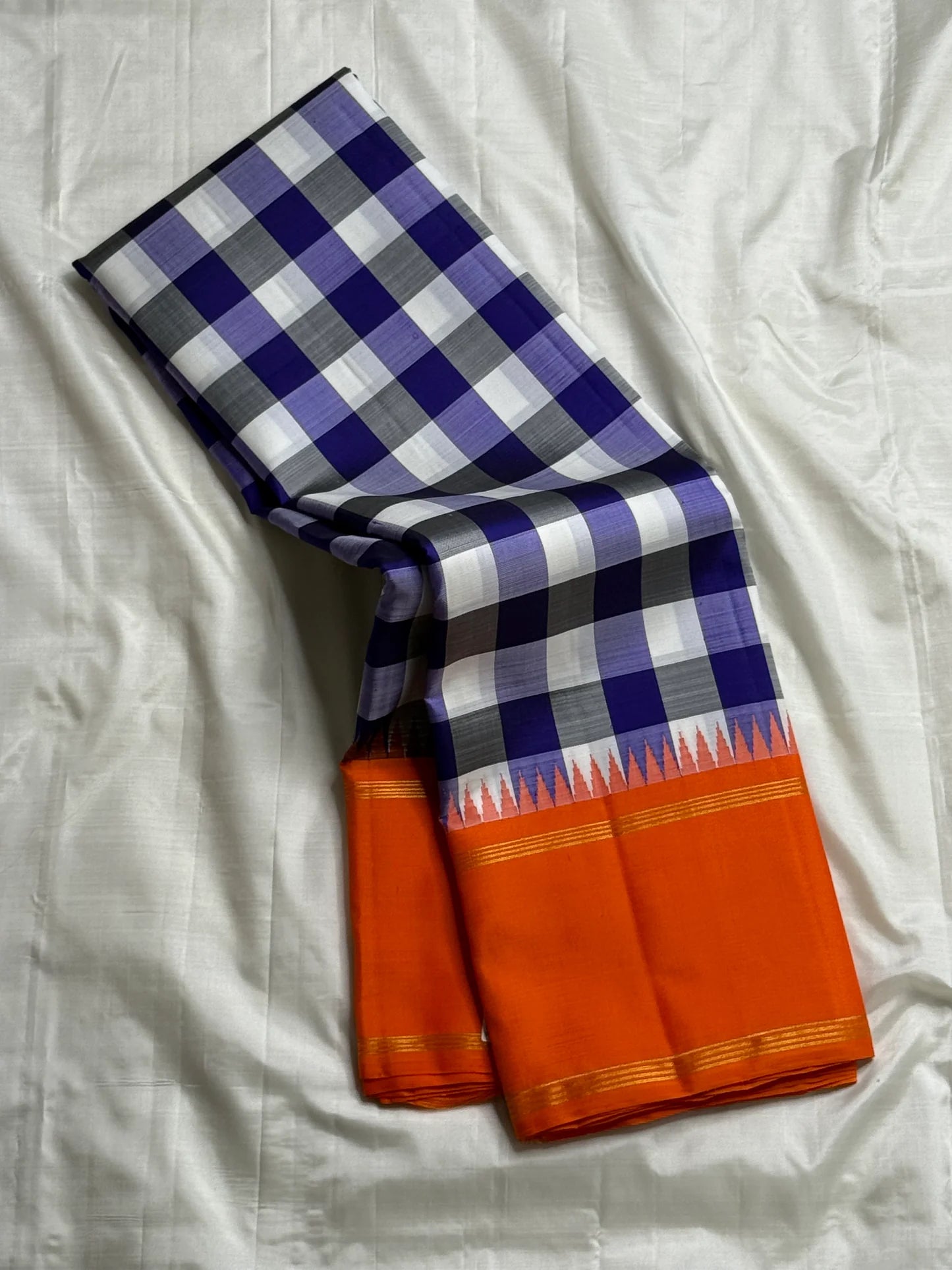 Lilac Indigo Kattam — Pure Silk Kanchipuram Saree
Bold indigo–lilac–white checks with tangerine korvai borders & gold temple edging
Silk Mark Certified • Free USA Shipping • Ships in Two Weeks