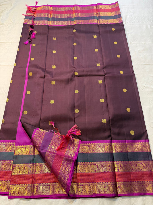 Coffee Brown Rajam – Pure Kanchipuram Silk Saree
Coffee Brown Body with Gold Zari Buttas
Rani Pink Korvai Borders with Temple, Peacock & Elephant Motifs
Grand Rani Pink Zari Brocade Pallu with Vertical Stripes & Tassels
Silk Mark | ships in two weeks