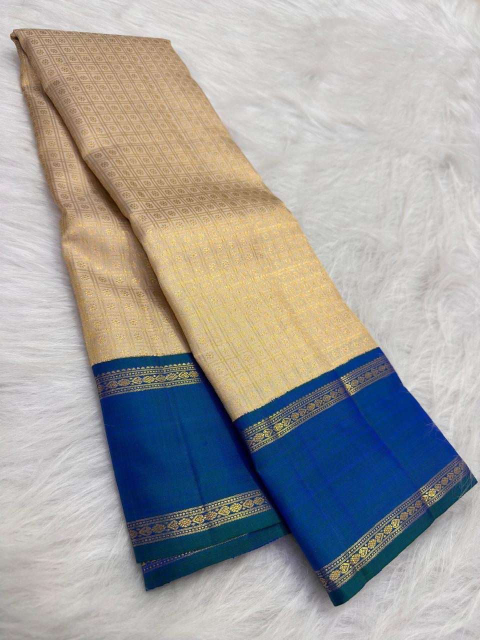 Grand peacock-blue and green shot-colour Kanjivaram pallu densely woven with gold geometric and floral zari bands.
