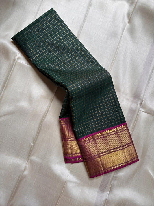 Pachai Zari Kattam – Pure Kanchipuram Silk Saree
Deep Emerald Green Body with Gold Zari Checks
Broad Golden Border with Magenta Highlights & Temple Motifs
Royal Magenta Pallu with Lustrous Zari Stripes

Silk Mark Certified, delivery in 2 weeks