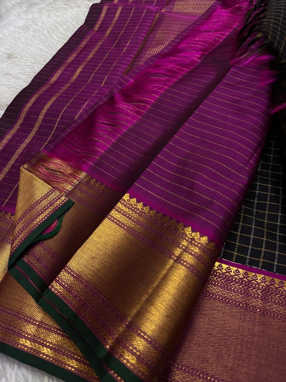 Charcoal Zari Kattam – Pure Kanchipuram Silk Saree
Rich Charcoal Black Body with Gold Zari Checks
Broad Golden Border with Magenta Highlights & Green Selvedge
Royal Magenta Pallu with Lustrous Zari Stripes

Silk Mark Certified, delivery in 2 weeks