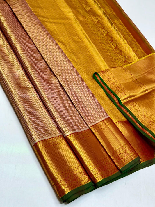 A resplendent blend of maroon rust & green, framed by rich gold zari borders. The pallu gleams with traditional thazhampoo motifs