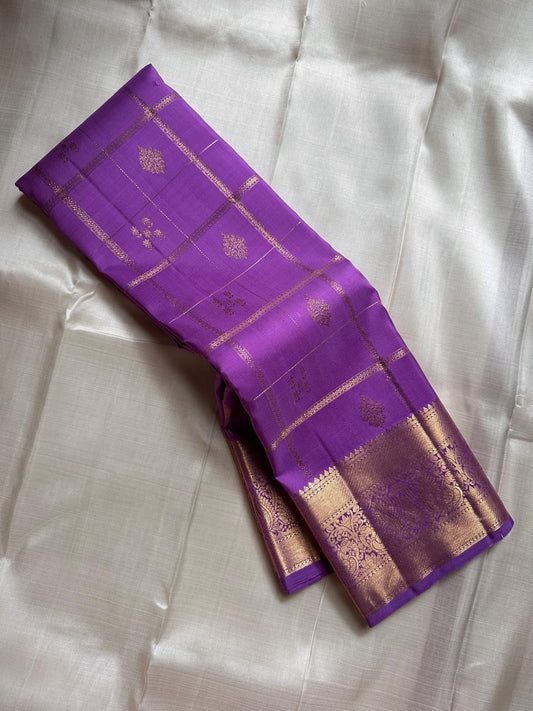 Nayaki ✨ — Lavender Pure Kanchipuram Silk Saree
With Zari Kattam Checks Across the Lustrous Body
Interspersed Floral Buttas in Gleaming Gold Zari
Majestic Peacock Motif Border in Heritage Weave
Grand Lavender Pallu with Rich Zari Brocade Artistry