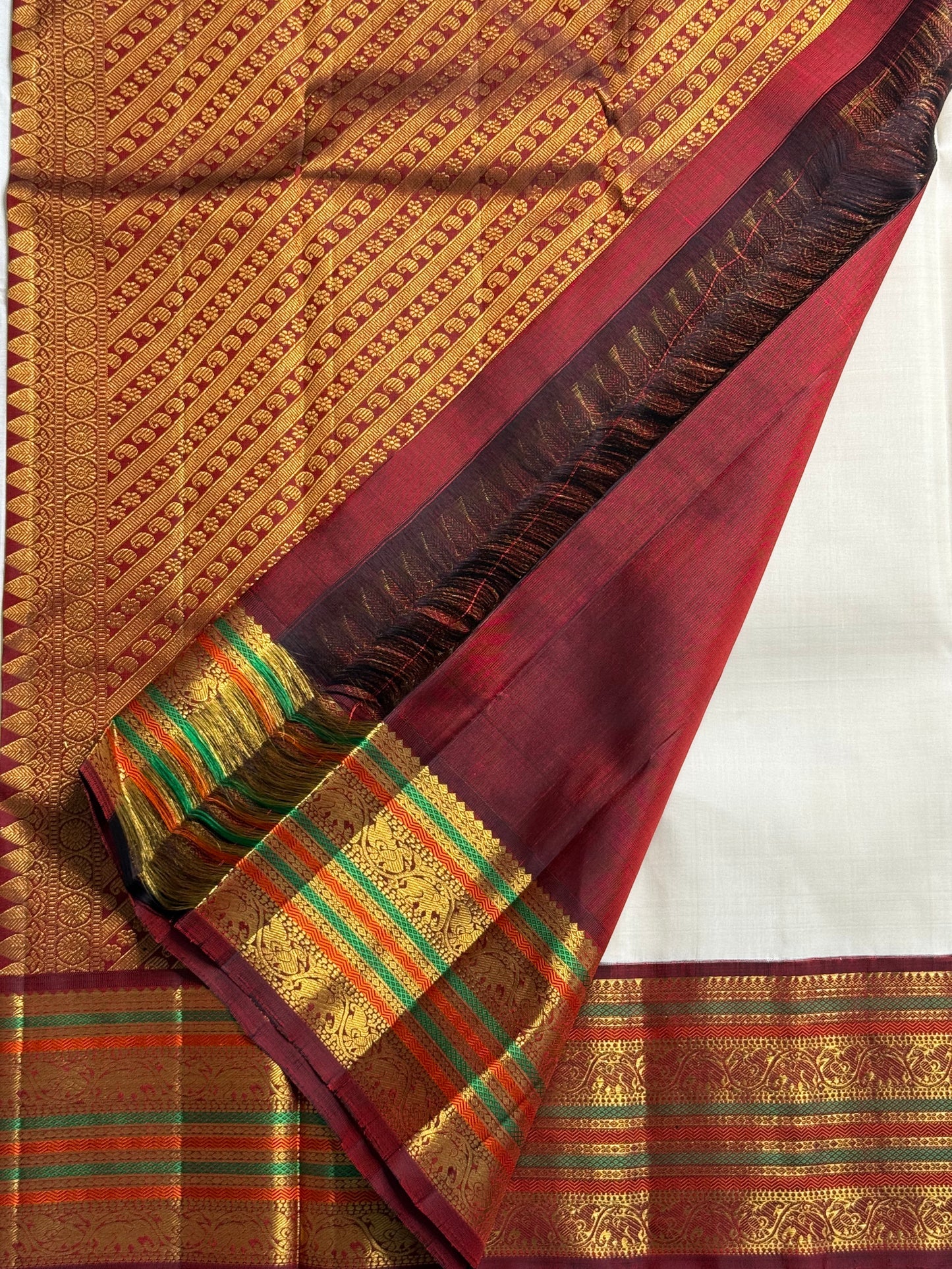 Parakkum Kili — Ivory Pure Silk Kanchipuram

Ivory body with fine zari coin buttas ✨
Rust-orange korvai borders with mayil & temple motifs 🌸
Grand rust-orange zari brocade pallu with tassels 🪔
Silk Mark Certified • Free Shipping USA • Ships in Two Weeks
