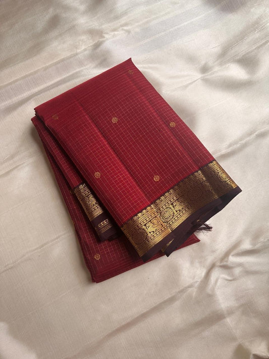 Komala – Deep Cherry Red Kanchipuram Pure Silk Saree with Coffee Brown Border
With petite kamalam motifs, peacock borders, and a grand grid zari pallu