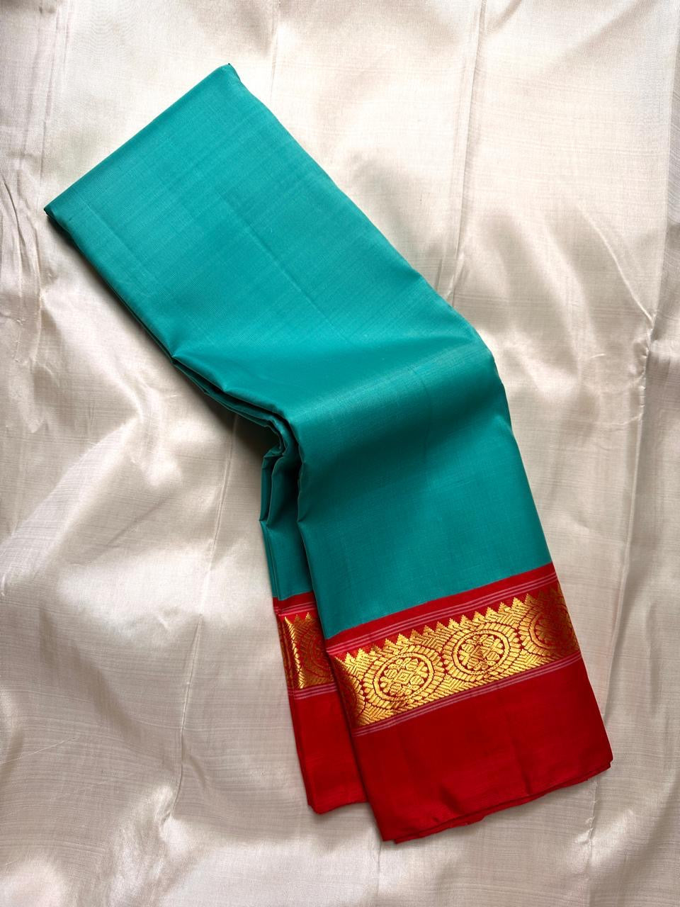 Close-up of red kaal erangina Kanchipuram silk pallu showcasing dense gold zari weaving and traditional circular motifs.