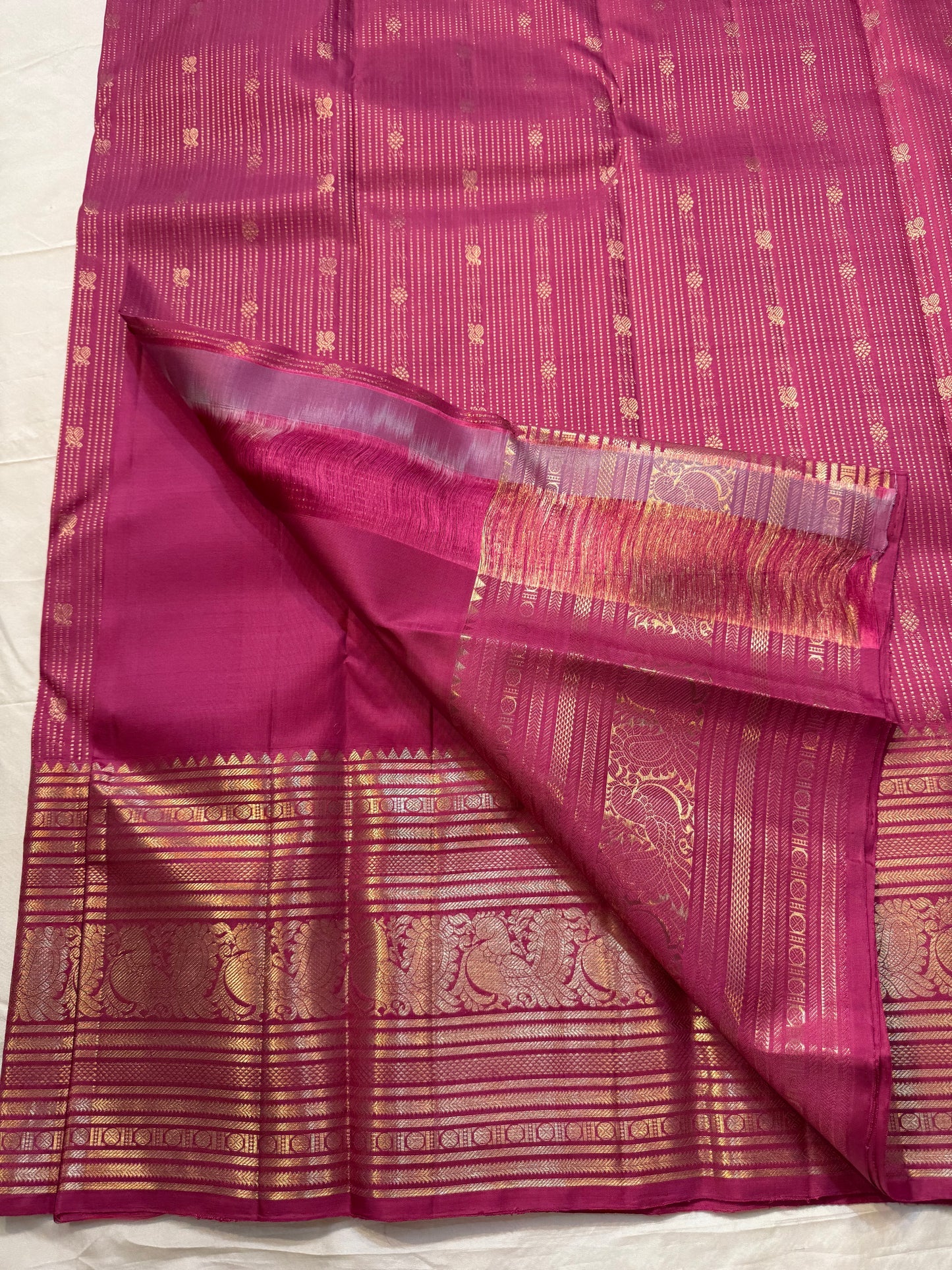 Kanakamalli — Pure Kanchipuram Silk Saree
Rani rose / magenta silk with vertical zari lines & gold peacock borders
Silk Mark Certified • Blouse Stitching Available ($30) • Free Shipping within USA • Ships in Two Weeks