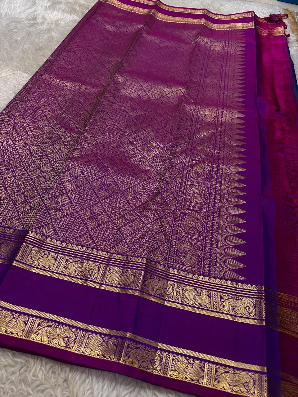 Purple Allure – Pure Kanchipuram Silk Saree
Peacock-blue body adorned with petite zari floral buttas 🌸
Contrast royal-purple border with grand elephant procession 🐘
Rich zari brocade pallu in floral motifs ✨

Silk Mark Certified, delivery in 2 weeks