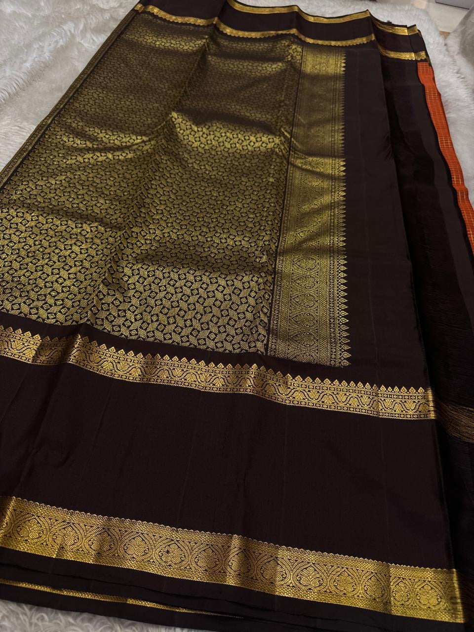 Gilded Rust Kattam – Pure Silk Kanchipuram Saree

Rust-orange kattam (checks) body with petite zari buttas ✨
Deep brown  korvai border with intricate gold zari design 🌸
Grand zari-rich pallu 💛
Silk Mark Certified ✅ | ships in two weeks