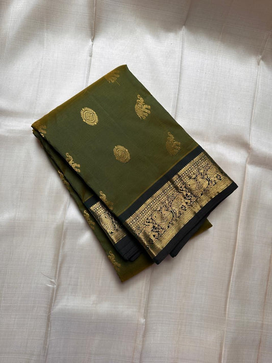 Olive Pachai – Pure Korvai Kanchipuram Silk Saree
Olive green body with gold zari gaja & medallion buttas
Contrast black korvai border with peacock & floral vines
Grand brocade pallu with lattice & temple patterns
Silk Mark Certified …chk description