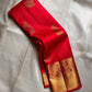 A traditional Kanjivaram (Kanchipuram) silk saree, vibrant red orange peacock floral motifs bavanji border and ornate grid motif Pallu