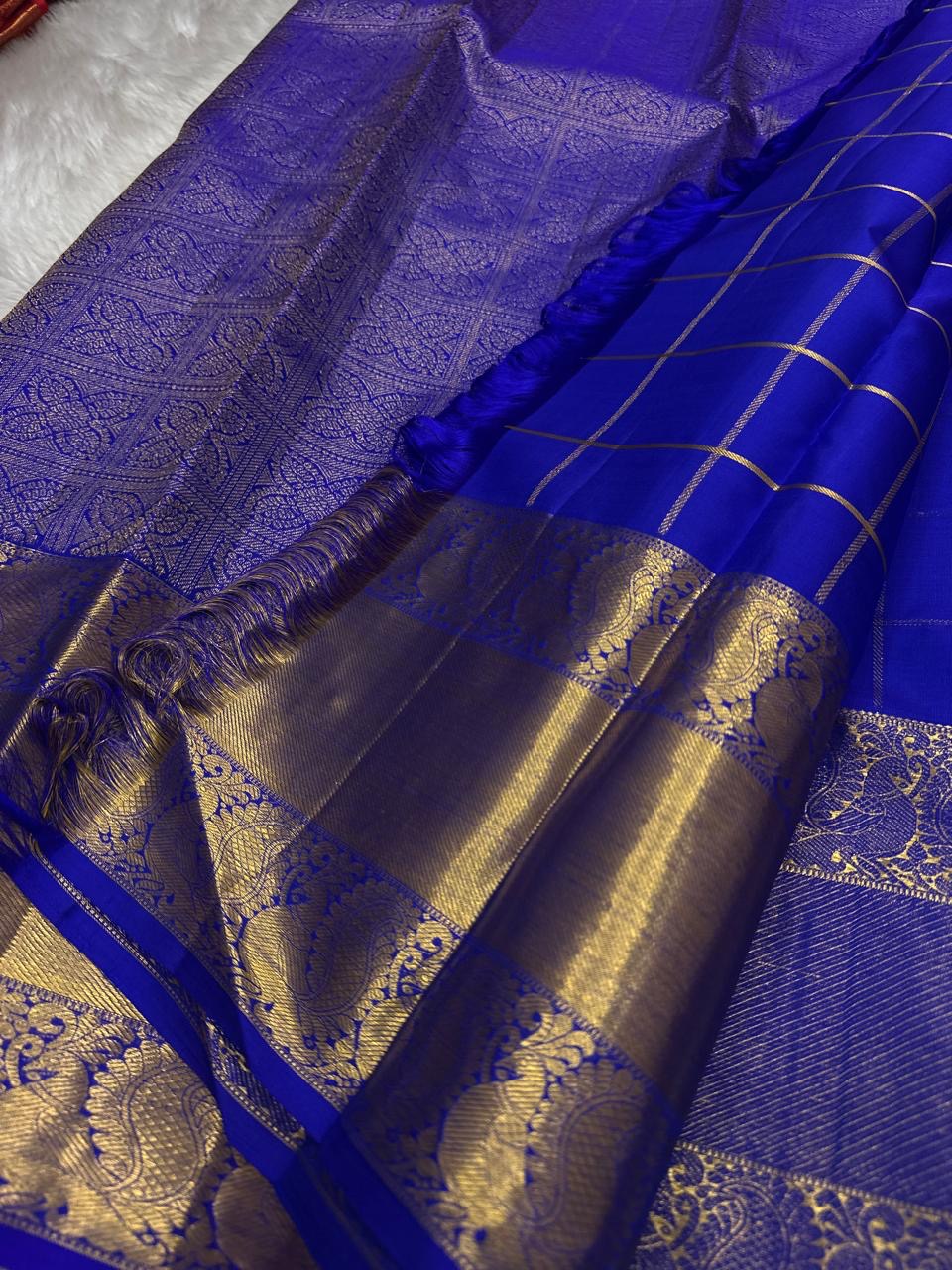 Kalyana Neelam Kattam — Kanchipuram Pure Silk

Deep royal neelam blue body with kattam (grid) checks & mayil buttas

Grand gold kaddi border with ornate paisley vines; rich zari pallu

Silk Mark Certified | Free Shipping within USA

Dispatch in 1 Week