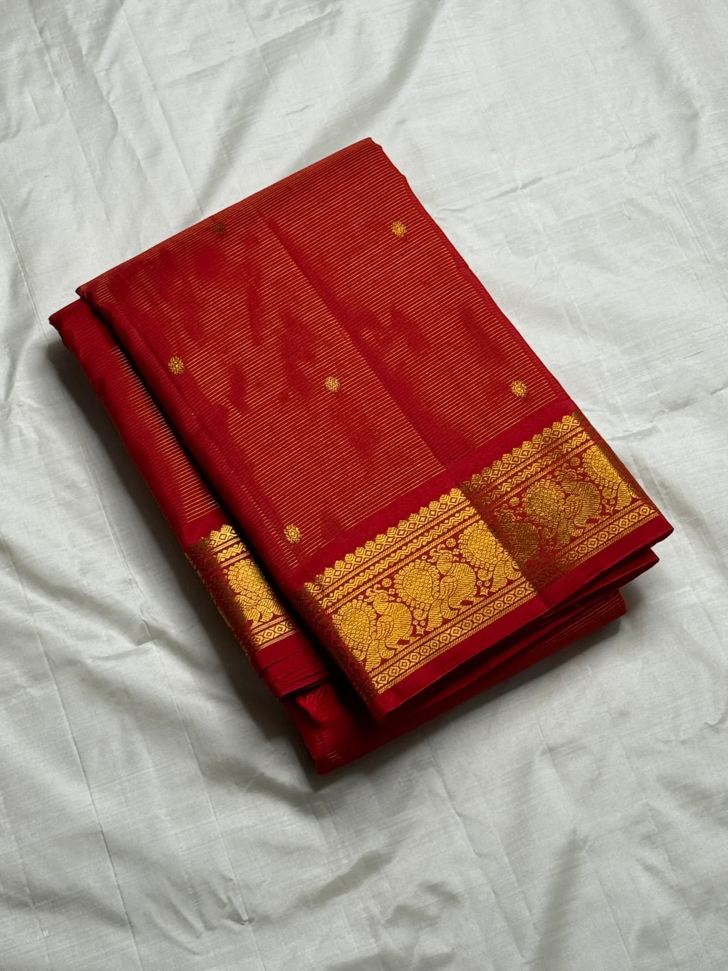 Vermillion Swarna Vairaoosi — Pure Kanchipuram Silk Saree
Vermillion red body with fine vairaoosi stripes, gold rosette buttas, and Gandaberunda borders in antique zari.
Silk Mark Certified • Free Shipping within USA • 2 weeks