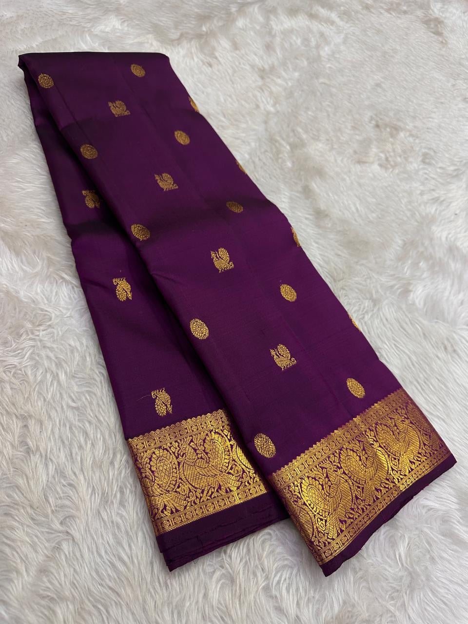 Handwoven Kanjeevaram silk saree featuring deep amethyst purple body and traditional gold zari buttas