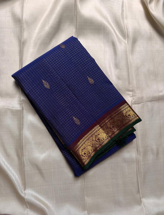 Midnight Oosikattam ✨ – Pure Kanchipuram Silk Saree
Deep Midnight Blue Body in Oosi Zari Kattam with Leaf Buttas
Maroon Korvai Border with Green Selvedge & Elephant Motifs
Opulent Maroon Pallu with Intricate Gold Zari Brocade
Silk Mark Certified |