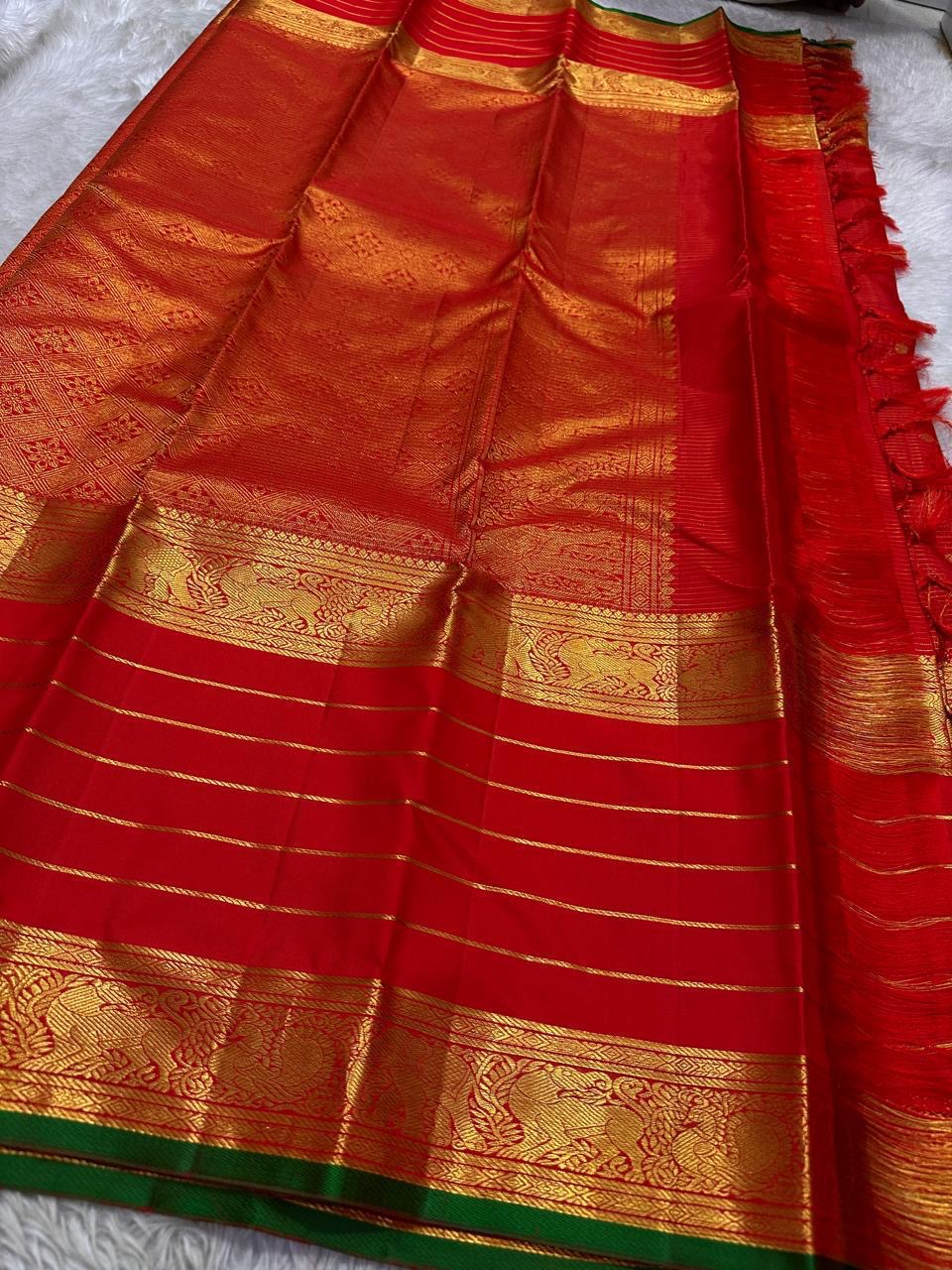 Full layout of red Kanchipuram silk saree with grand woven zari pallu, elephant borders and gold horizontal stripes.