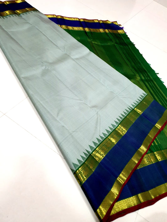 Podi Kattam Emerald Pillar Moggu – Pure Kanchipuram Silk Saree
Seafoam–Ice Blue Micro Checks with Korvai Emerald Green Border
Neelam Blue Panel & Gold Zari pillayar Moggu Motifs
Rich Emerald Zari-Striped Pallu | silk mark certified Saree ships in two week