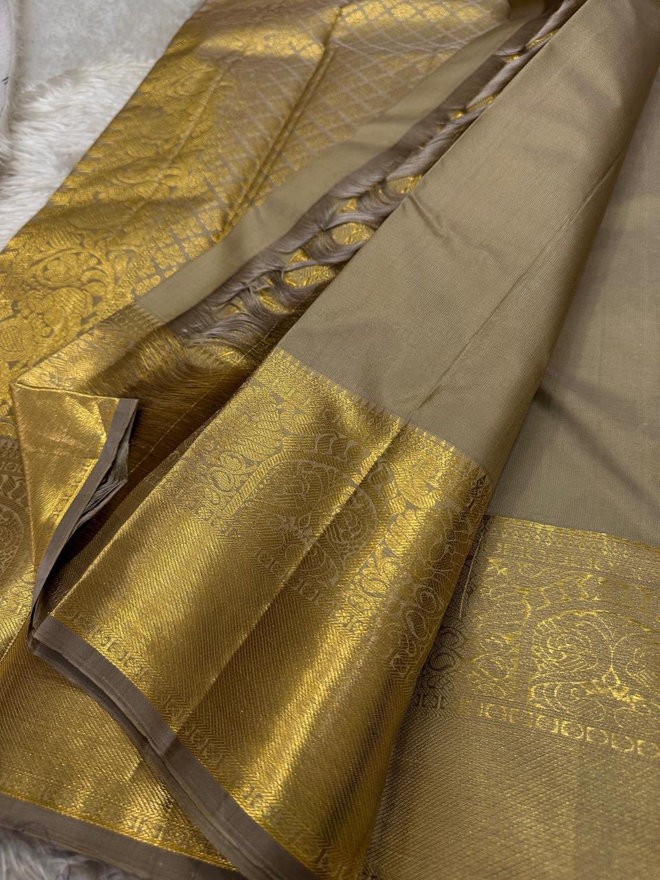 Chiku Orchard – Pure Kanchipuram Silk Saree
Elegant Chiku (Taupe) Body with Gold Paisley Buttas
Rich Antique Gold Zari Borders with Floral Motifs
Grand Gold Zari Pallu with Traditional Kattam Design
Silk Mark Certified | Ready to Ship | ships in two weeks