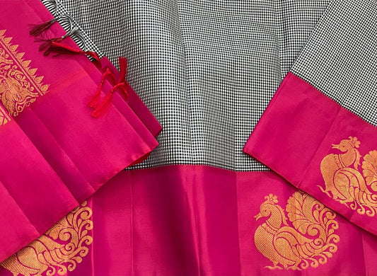 Aaradhana Kattam — Pure Kanchipuram Silk Saree (Black & White × Rani Pink)
Classic black-and-white micro checks with rich rani-pink korvai borders and zari peacock motifs
Silk Mark Certified • Fall & Pico Done • Blouse Stitching Available ($30) • Free Shi