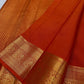 Maroon and red Kanchipuram silk sarees with antique gold zari borders displayed on ivory backdrop.
