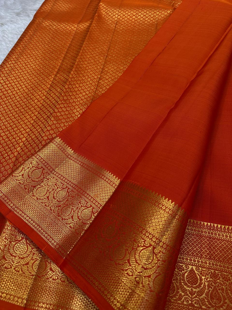 Maroon and red Kanchipuram silk sarees with antique gold zari borders displayed on ivory backdrop.
