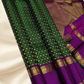 An heirloom-worthy drape woven in the finest 2G pure silk, this traditional Kanchipuram saree brings together the timeless beauty of zari buttas and checks in a rich green body. The contrast purple  rettapet border stands bold and elegant